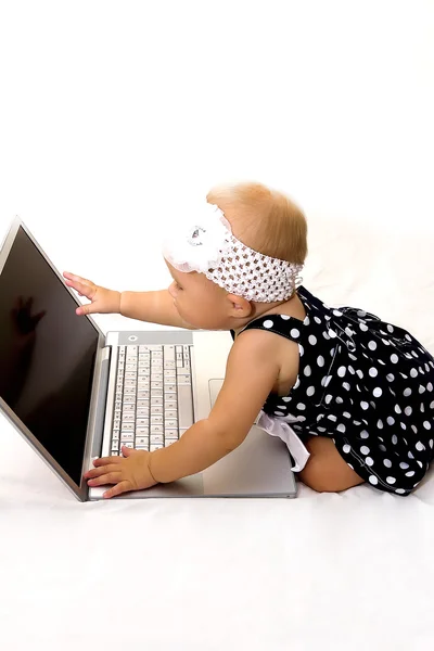 Söt baby med en bärbar dator. — Stockfoto