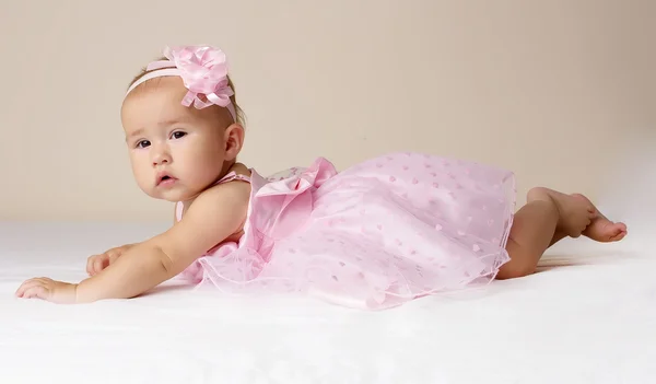 Meisje van de baby in roze jurk. — Stockfoto