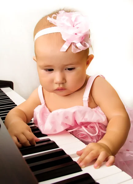 Mooie babymeisje speelt piano — Stockfoto