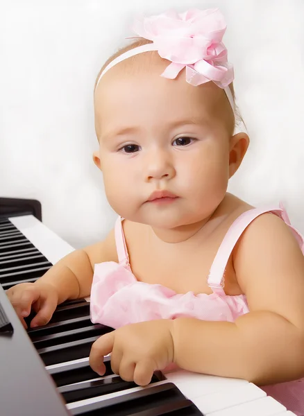 Beautiful baby girl plays piano — Stock Photo, Image