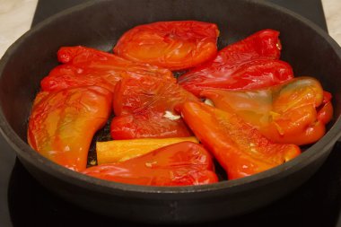 yuvarlak bir tavada közlenmiş kırmızı biber.