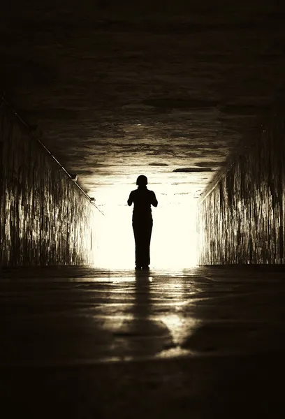 Silhouette di donna in un tunnel . Foto Stock