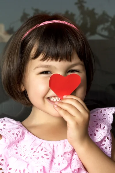 Little girl and red hearts. Stock Image