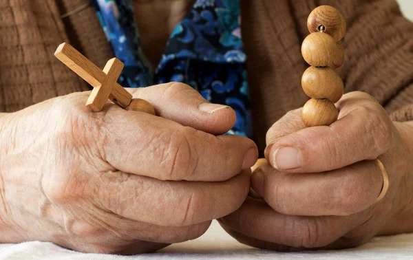 Manos de anciana sosteniendo rosario — Foto de Stock