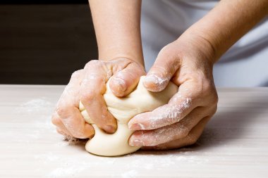 Hands kneading a dough. clipart