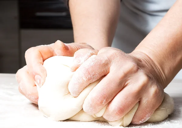 Händer som knådar en deg. — Stockfoto