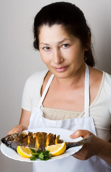 Chef fêmea mostra peixe dourado — Fotografia de Stock