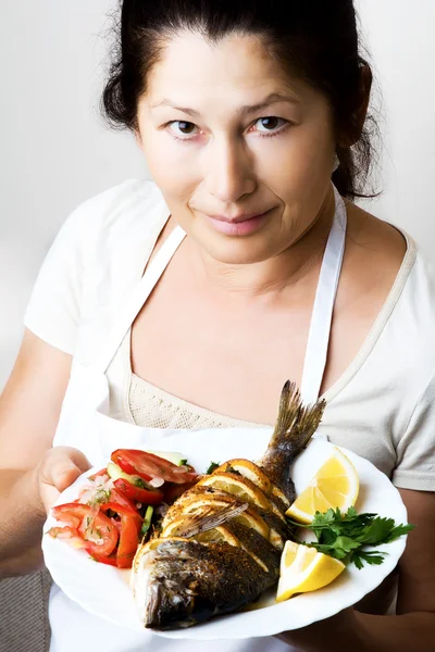 Female chef shows sea bream fish — Stock Photo, Image