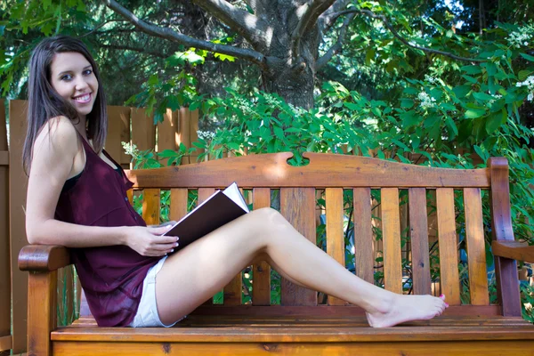 Pretty teen girl reading outside on a bench - copyspace — Stock Photo, Image