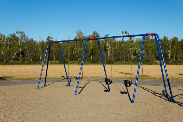 Swing set en el patio de recreo —  Fotos de Stock
