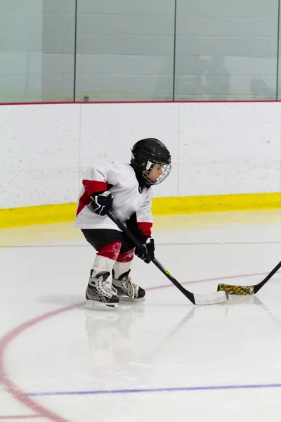 Kleiner Junge spielt Eishockey lizenzfreie Stockfotos