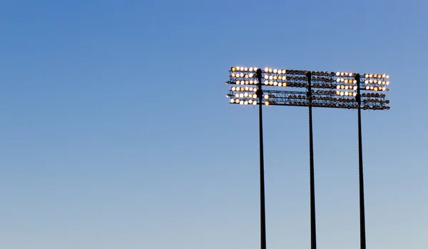 푸른 하늘 위에 경기장 조명 — 스톡 사진