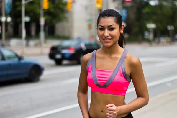 Ajuste mujer joven corriendo en una calle de la ciudad ocupada — Foto de Stock