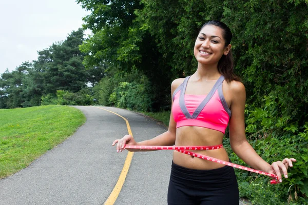 Young woman measures her waist — Stock Photo, Image