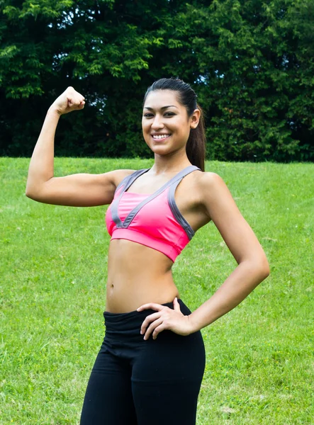 Joven en forma mujer flexiona sus músculos —  Fotos de Stock