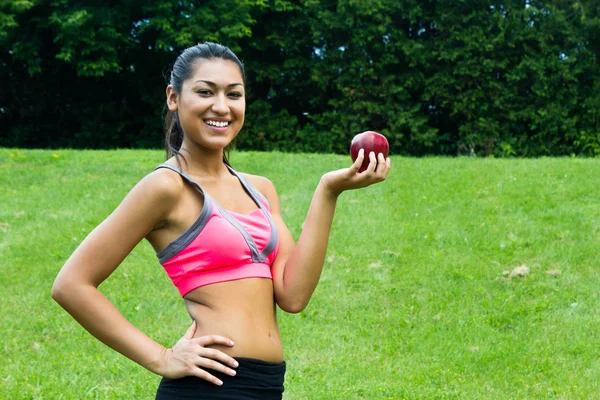 Convient à une jeune femme avec une pomme dans le parc — Photo
