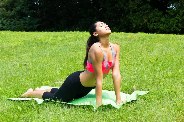 Jonge vrouw doet yoga in het park — Stockfoto