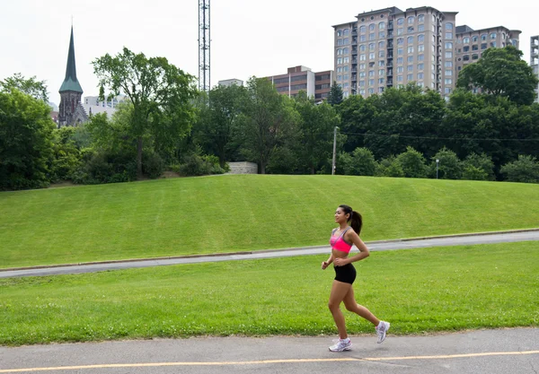 都市公園で走っている女性に適合します。 — ストック写真