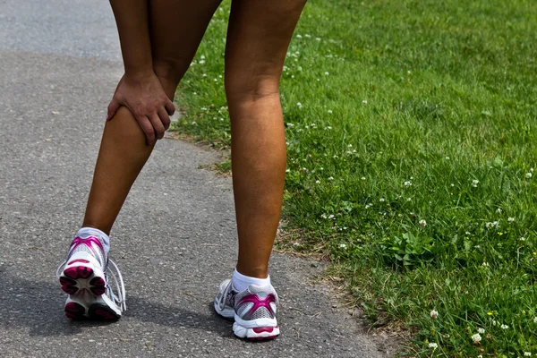 Young woman with running injury on calf — Stock Photo, Image