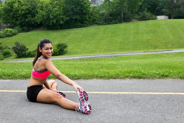 Mujer joven se estira antes de correr —  Fotos de Stock