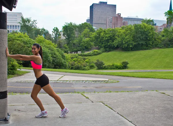 Giovane donna si allunga prima di correre — Foto Stock