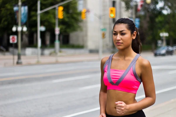 Ajuste mujer joven corriendo en una calle de la ciudad ocupada —  Fotos de Stock