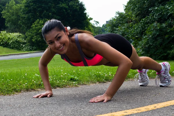 Fit jovem mulher fazendo flexões ao ar livre — Fotografia de Stock