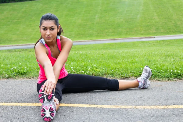 Young woman stretches before jogging — Stock Photo, Image