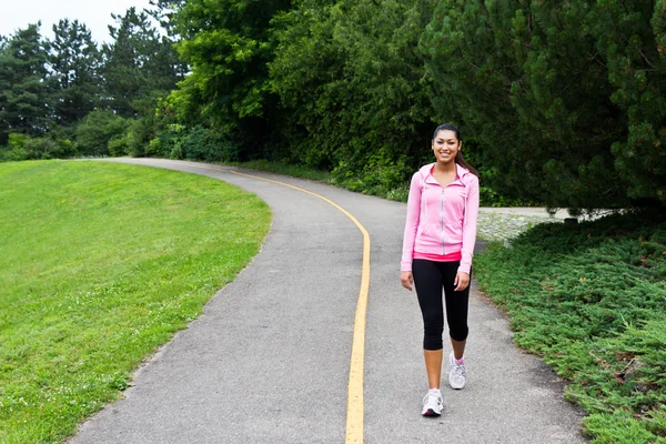 Kvinnan promenader på joggingspår — Stockfoto