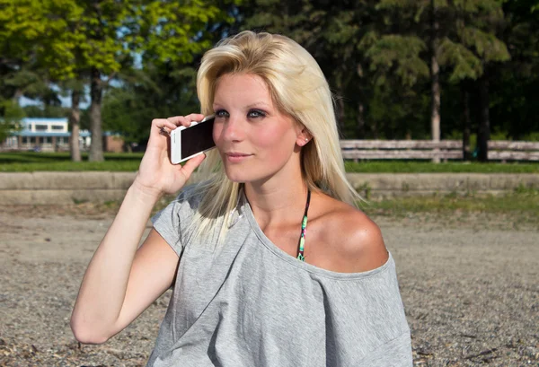 Ung kvinna prata smarta telefon på stranden — Stockfoto