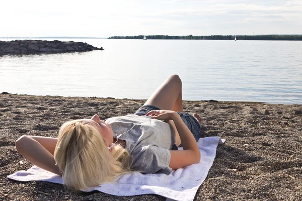 Mujer joven en la playa escuchando música — Foto de Stock