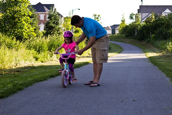 Child learning to ride a bicycle with father — Stock Photo, Image