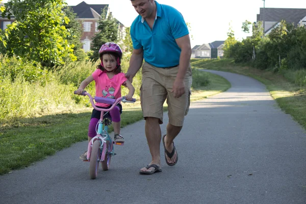 Child learning to ride a bicycle with father — Stock Photo, Image