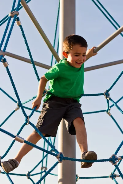 Bambino che gioca sulla struttura del parco — Foto Stock