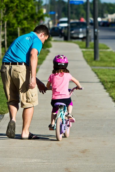Child learning to ride a bicycle with father — Stock Photo, Image