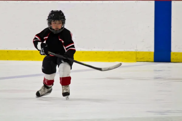 Buz pateni ve bir arena içinde hokey oynayan çocuk — Stok fotoğraf