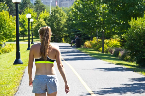 Woman walking along a jogging trail — Stock Photo, Image