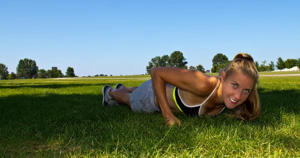 Fit, athletic woman doing push ups — Stock Photo, Image