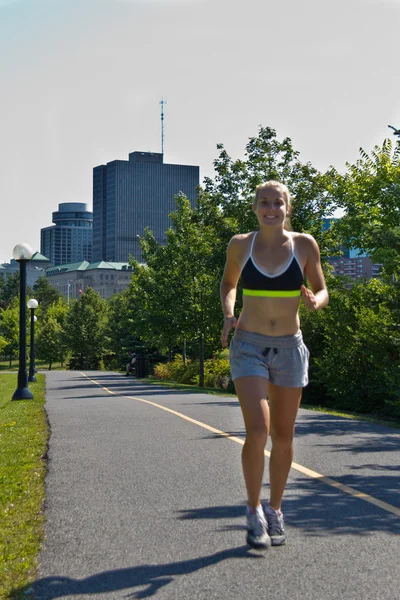 Mujer corriendo por un sendero de jogging en la ciudad — Foto de Stock