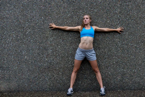 Adatta giovane donna spalmata contro il muro — Foto Stock