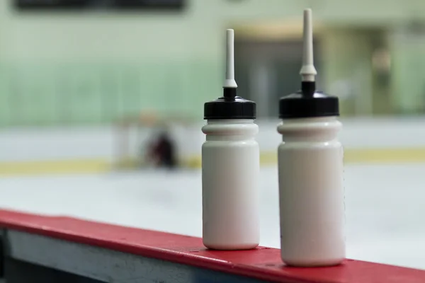 Бутылки с водой на досках на хоккейной арене — стоковое фото