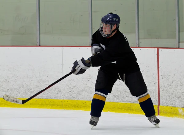Joueur de hockey tentant un tir pendant un match — Photo