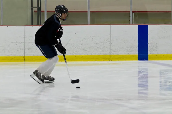 Jugador de hockey se pega maneja el disco — Foto de Stock