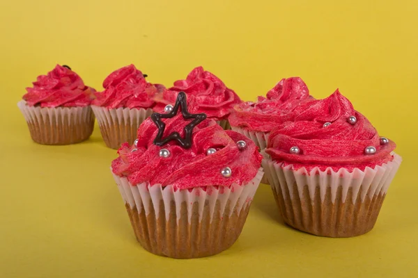 Grupo de cupcakes sobre fondo amarillo —  Fotos de Stock