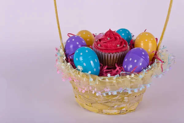 Basket with Easter eggs and cupcake — Stock Photo, Image