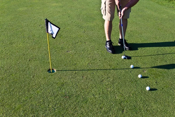 Golfer übt Putten mit mehreren Golfbällen — Stockfoto