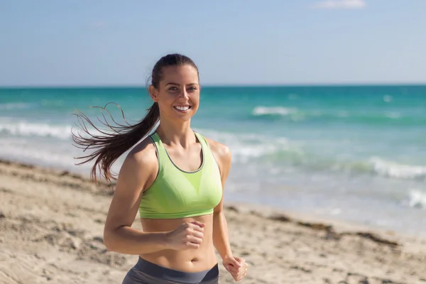 Femme hispanique courant sur la plage — Photo