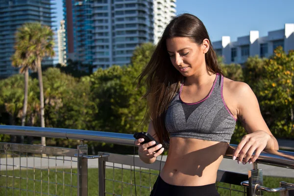 Spaanse vrouw luisteren naar muziek tijdens een training — Stockfoto