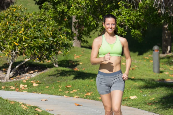 Mujer hispana trotando en un camino — Foto de Stock