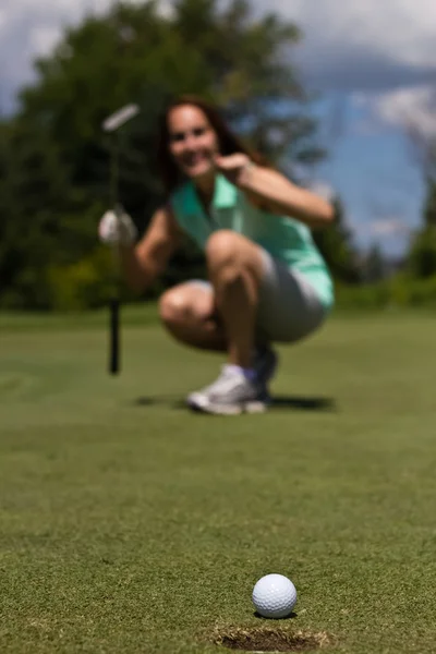 Mulher colocando a bola de golfe no copo - foco seletivo — Fotografia de Stock